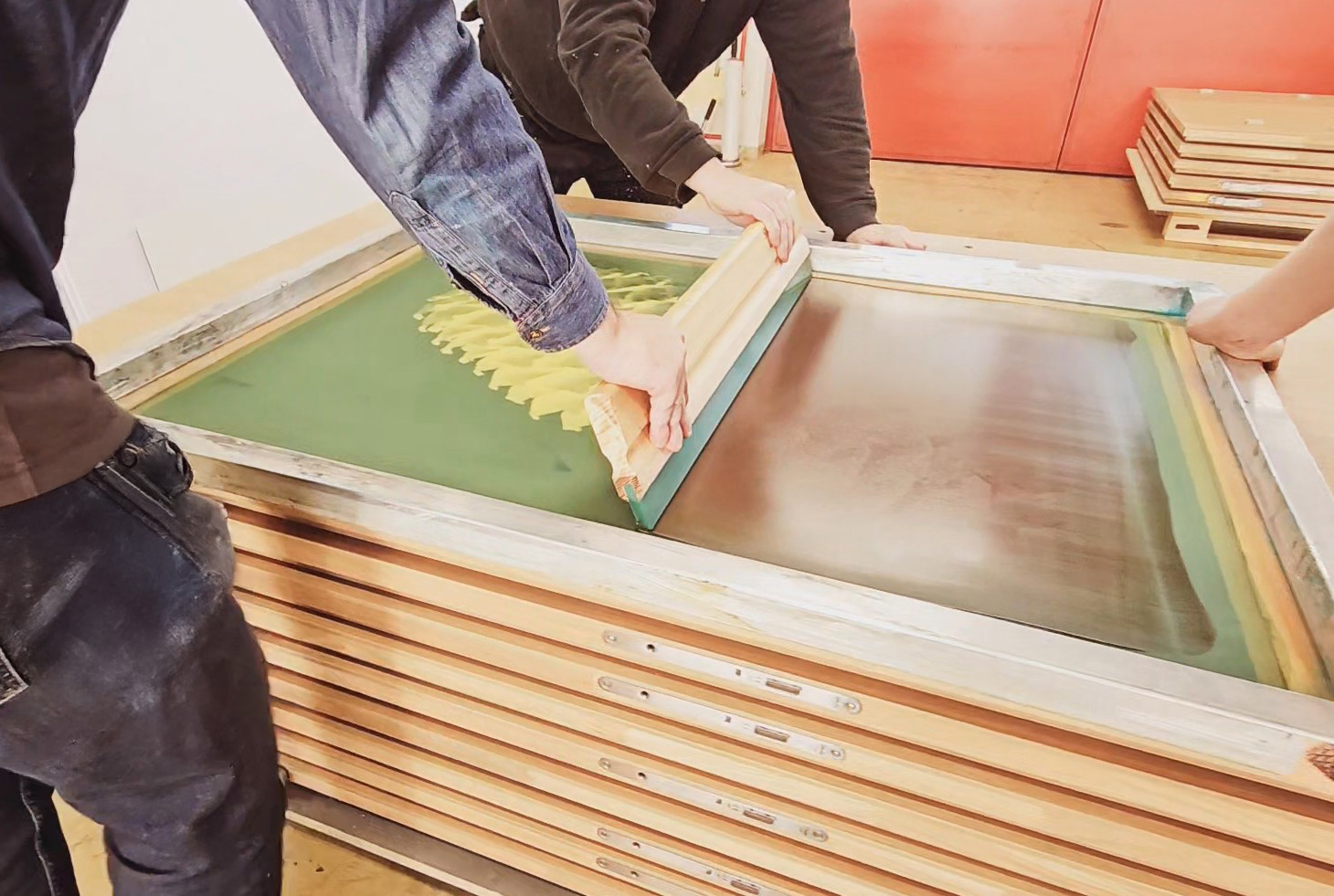 Siebdruck Farbe mit Rakel durch ein feinmaschiges Sieb